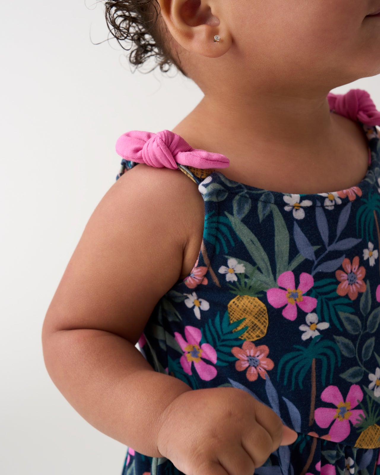 Close up of the bow detail on the Tropical Garden Baby Bow Strap Romper