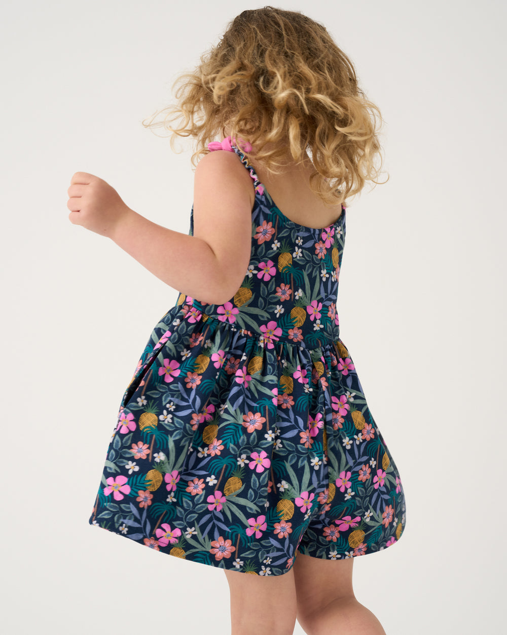 Back view of child wearing the Tropical Garden Bow Strap Romper