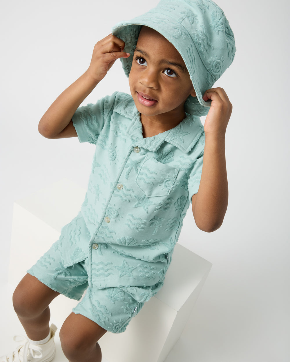 Boy wearing the Coastal Rays Bucket Hat and matching set