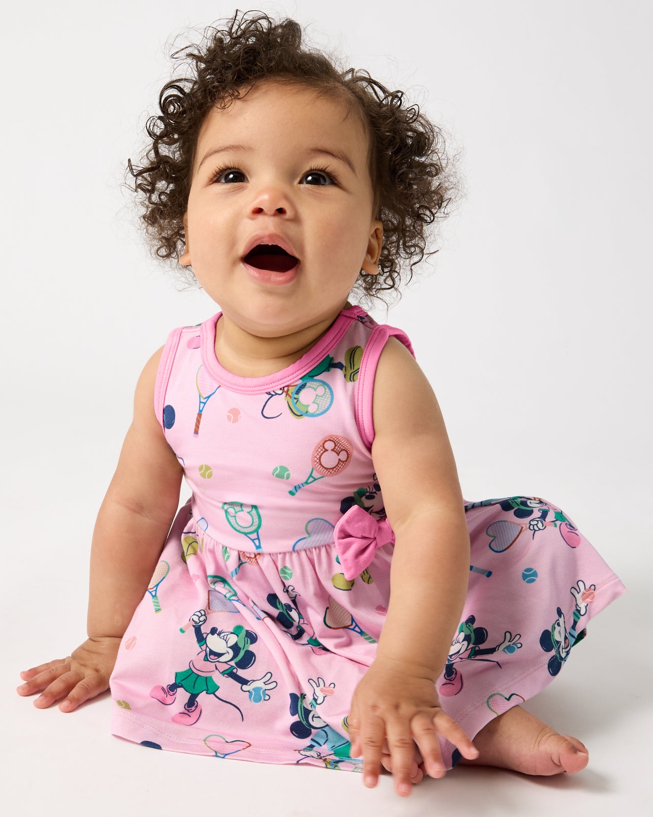 Sitting baby wearing the Disney Mickey Mouse & Minnie Mouse Match Twirl Dress with Bodysuit