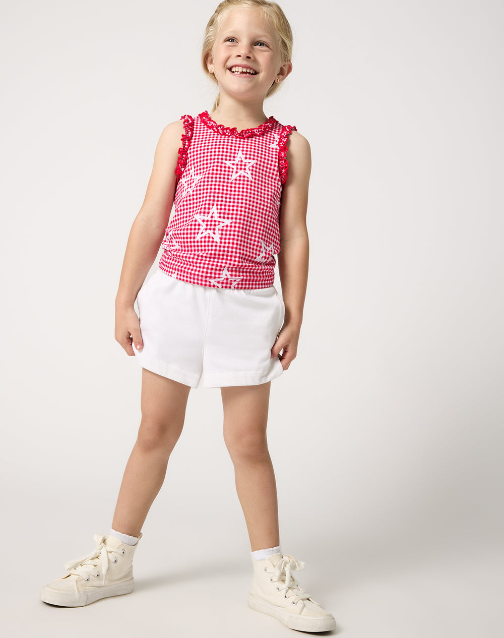 Girl wearing the Celebration Gingham Ruffle Tank Top with white denim shorts