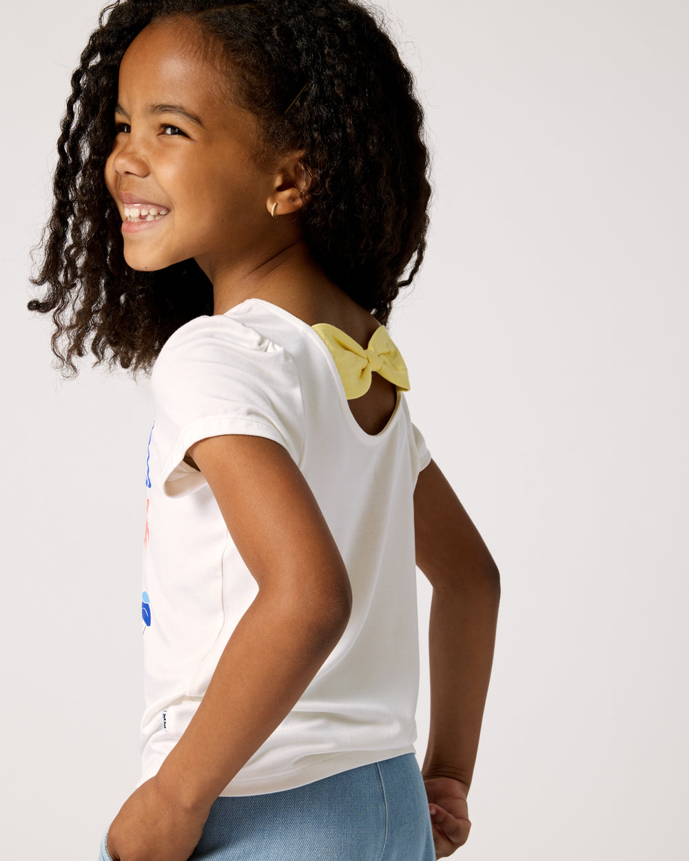 Back view of girl wearing the Ciao Bella Bow Back Puff Sleeve Tee