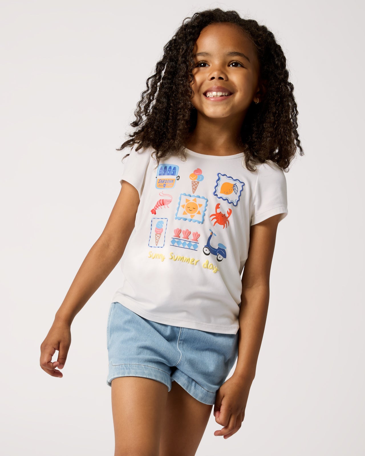 Girl wearing the Ciao Bella Bow Back Puff Sleeve Tee with denim shorts