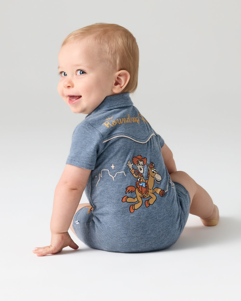 Back view of baby wearing the Disney & Pixar The Roundup Gang Polo Shorty Romper
