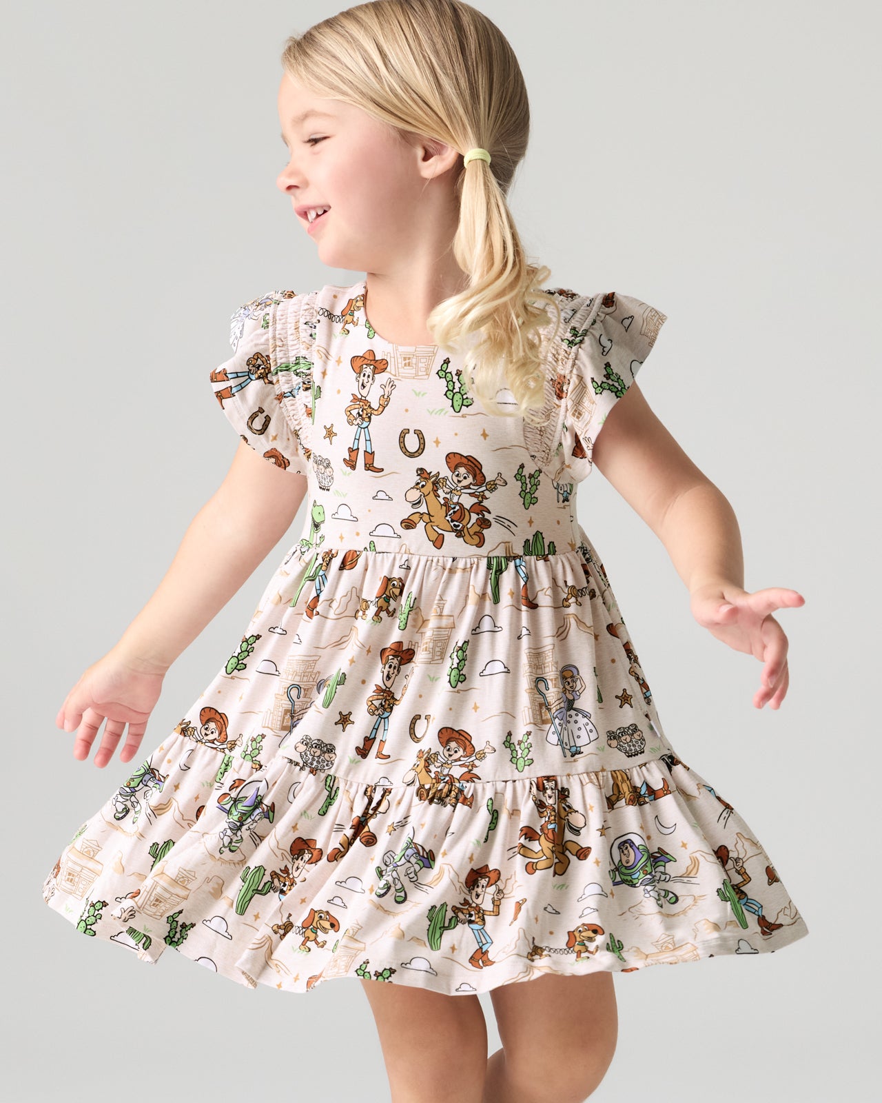 Girl wearing the Disney & Pixar Woody's Wild West Tiered Flutter Dress