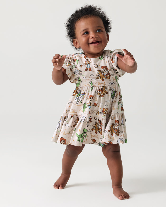 Toddler wearing the Disney & Pixar Woody's Wild West Tiered Flutter Dress with Bloomer