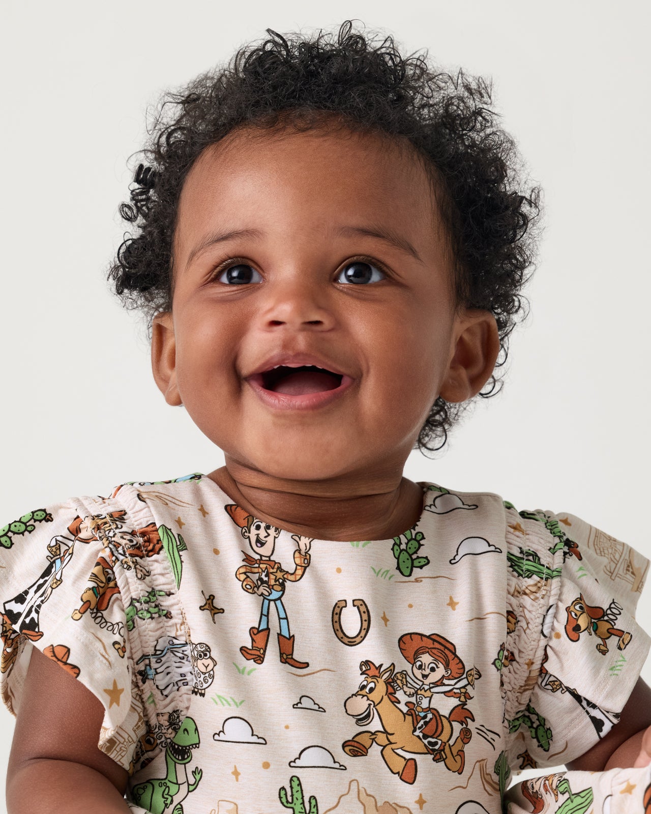 Close up of toddler wearing the Disney & Pixar Woody's Wild West Tiered Flutter Dress with Bloomer