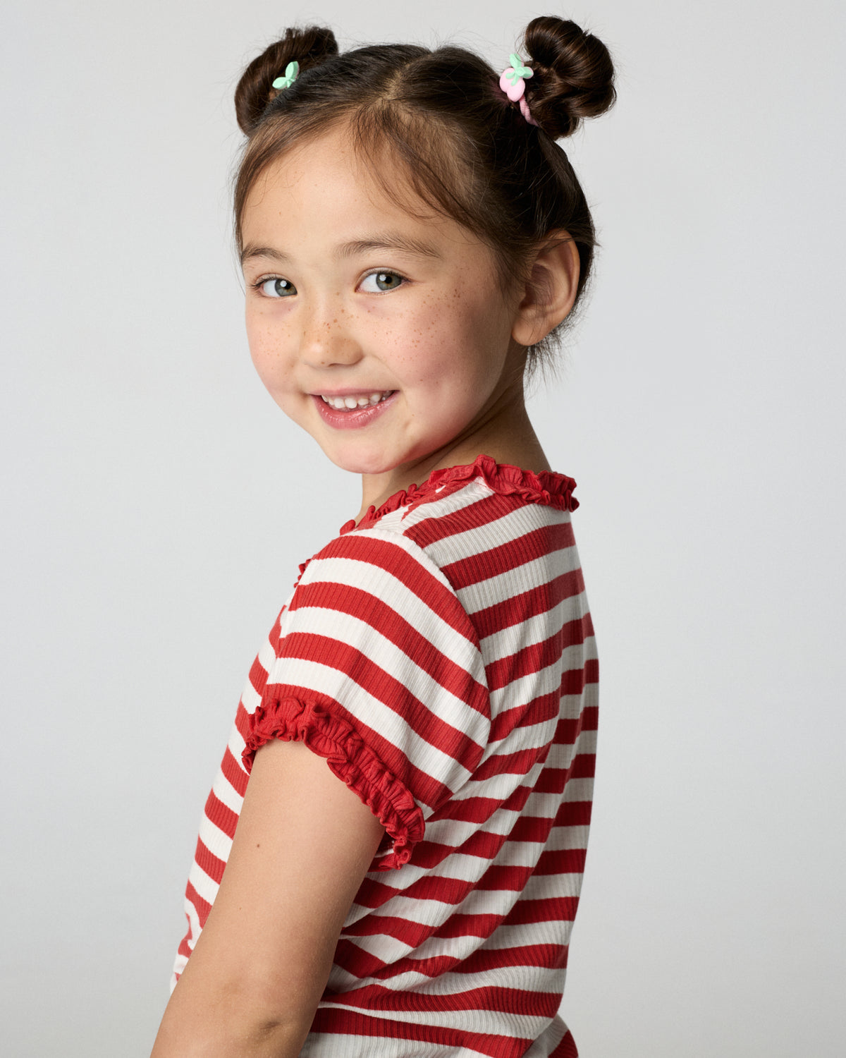 Back view of child wearing the Red Ember Stripe Ruffle Tee