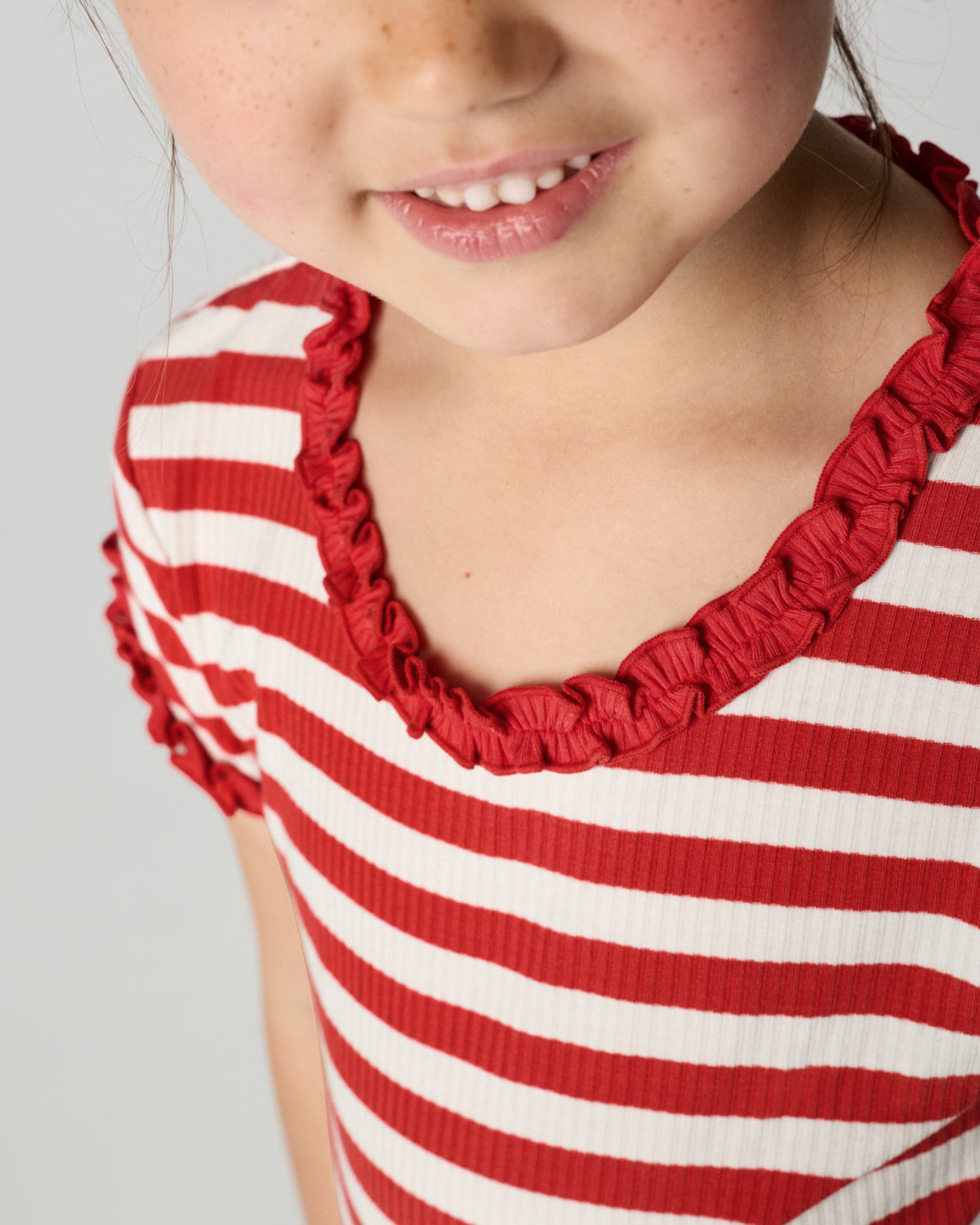 Close up of the ruffle detail on the Red Ember Stripe Ruffle Tee