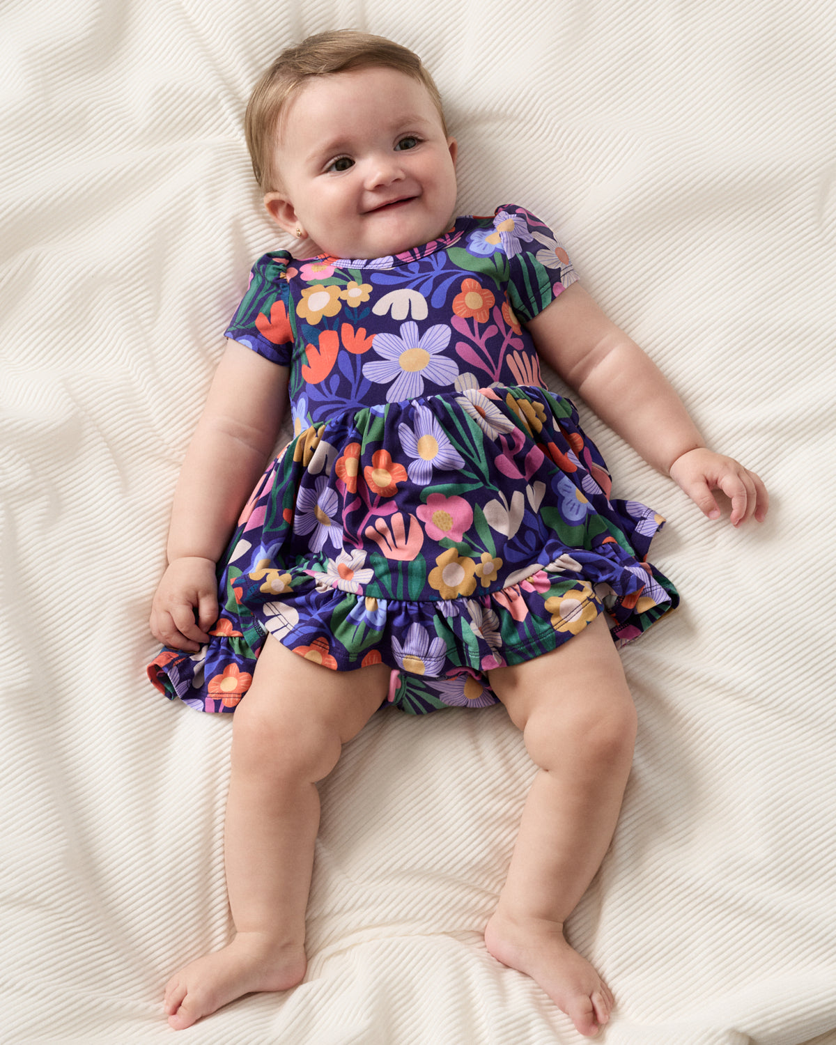 Aerial view of baby wearing the Wild Garden Ruffle Twirl Dress with Bodysuit