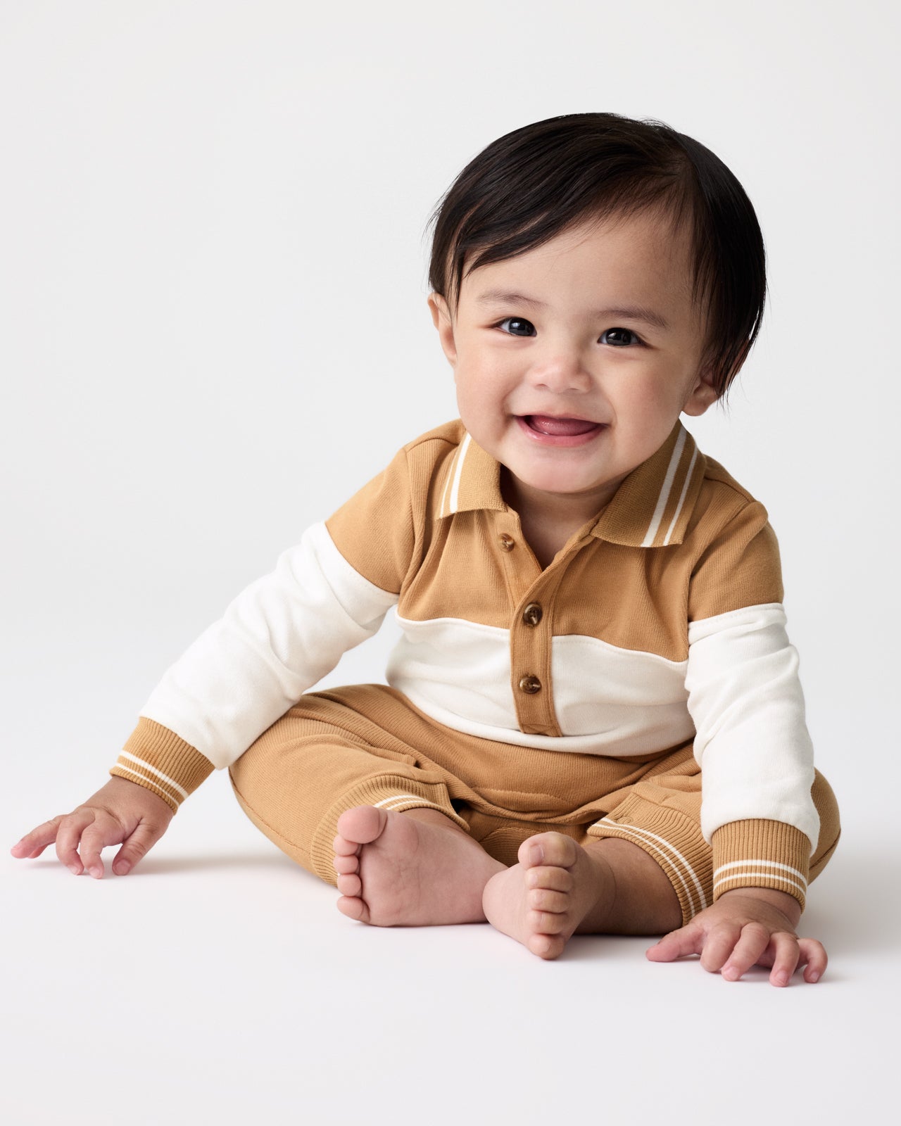 Sitting baby wearing the Maple Cream Polo Romper