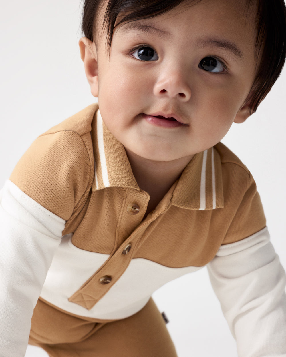 Close up of the henley button detail on the Maple Cream Polo Romper
