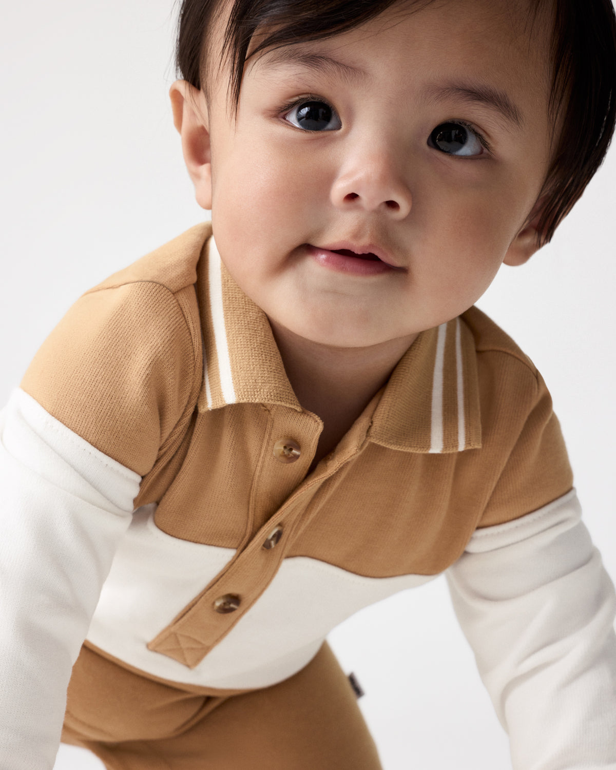 Close up of the henley button detail on the Maple Cream Polo Romper
