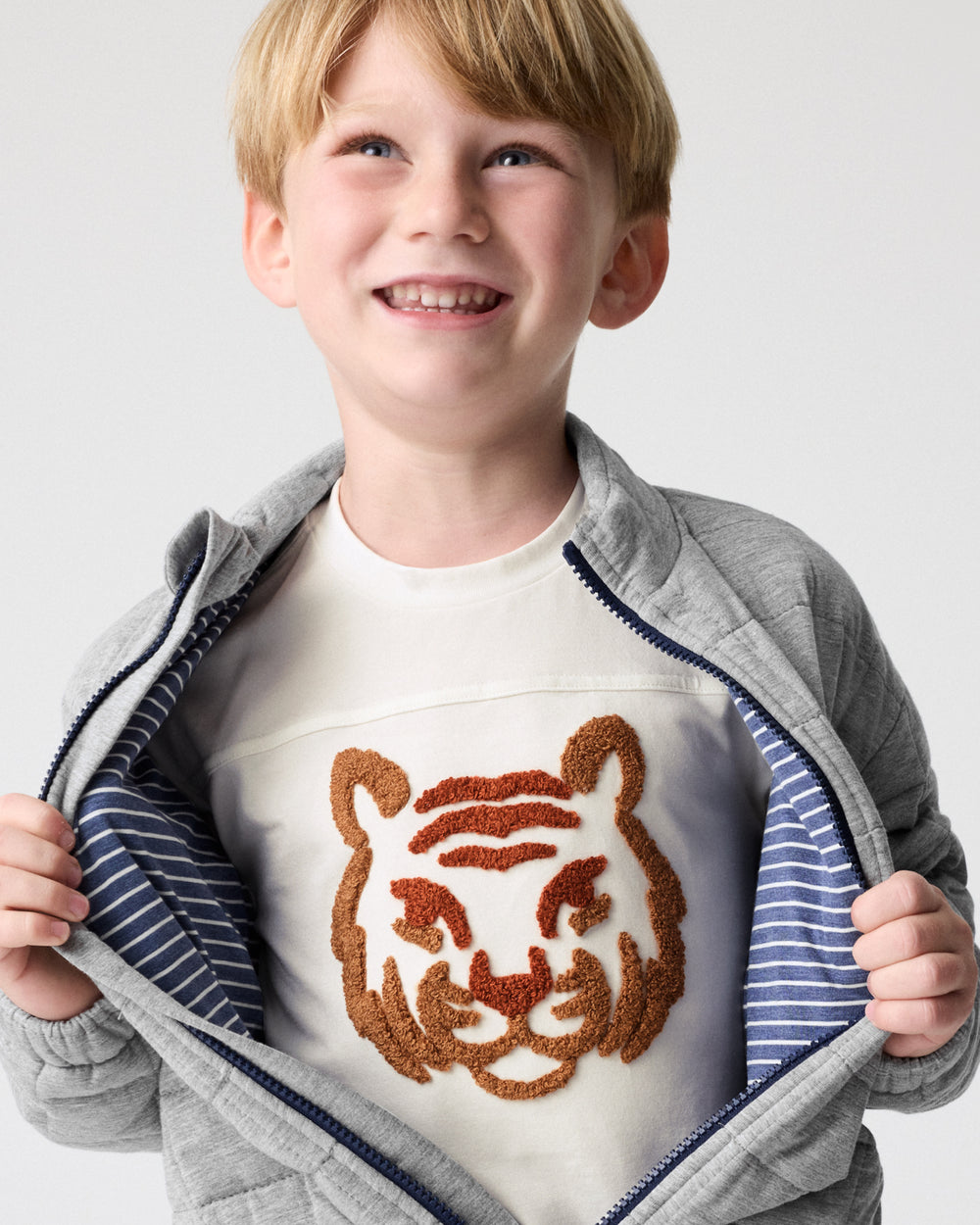 Boy wearing the Heather Gray Quilted Track Jacket layered over a tee