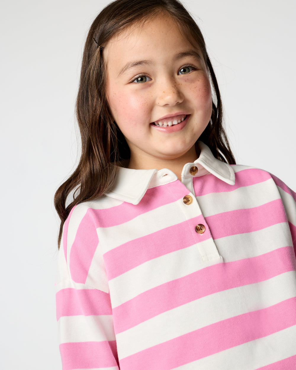 Close up of girl wearing the Pink Spark Stripe Polo Shirt