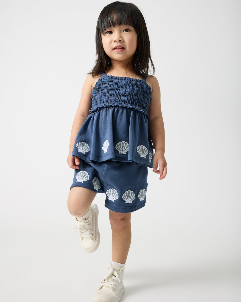 Girl wearing the Seashell Cove Smocked Tank & Shorts Set