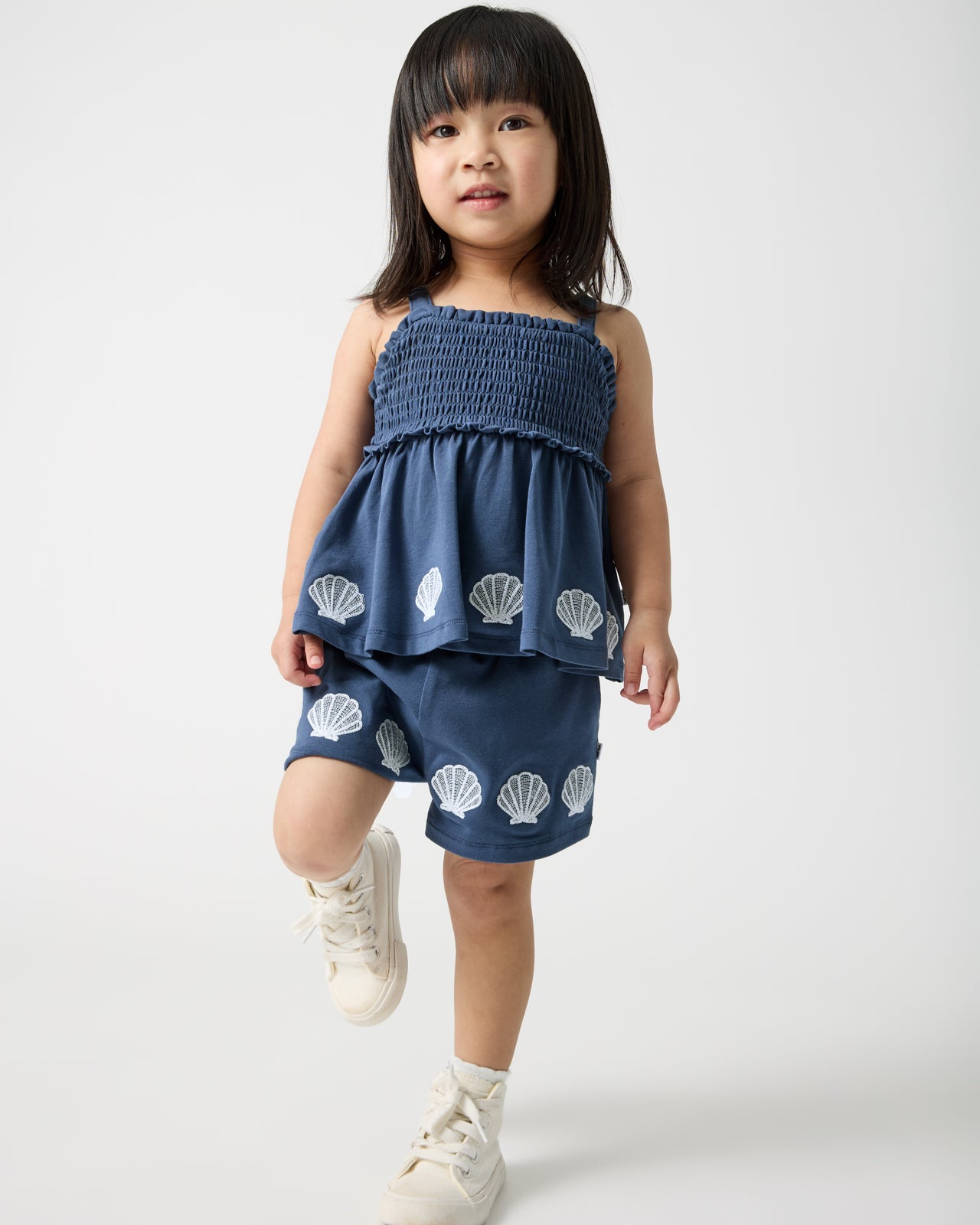 Girl wearing the Seashell Cove Smocked Tank & Shorts Set
