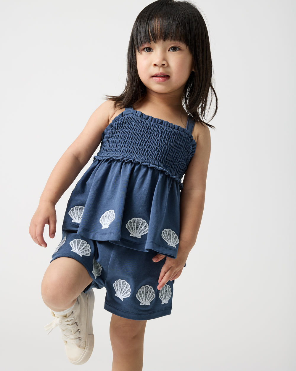Child in motion wearing the Seashell Cove Smocked Tank & Shorts Set