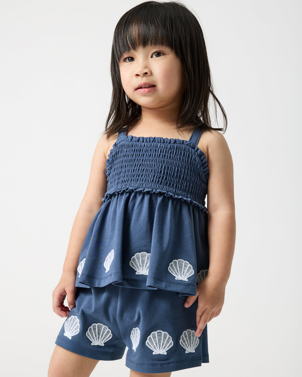 Close up of girl wearing the Navy Seashell Cove Smocked Tank & Shorts Set