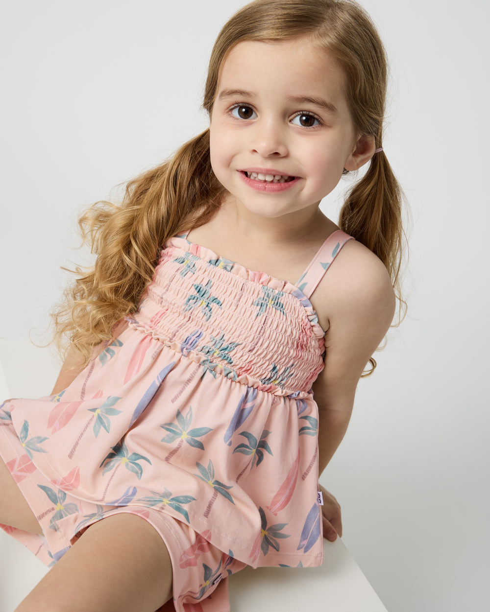 Sitting girl wearing the Palm Dunes Smocked Tank & Shorts Set