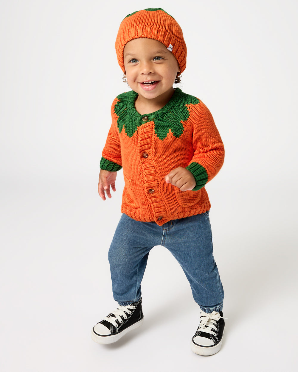 Walking toddler wearing the coordinating Pumpkin Sweater Beanie and Cardigan