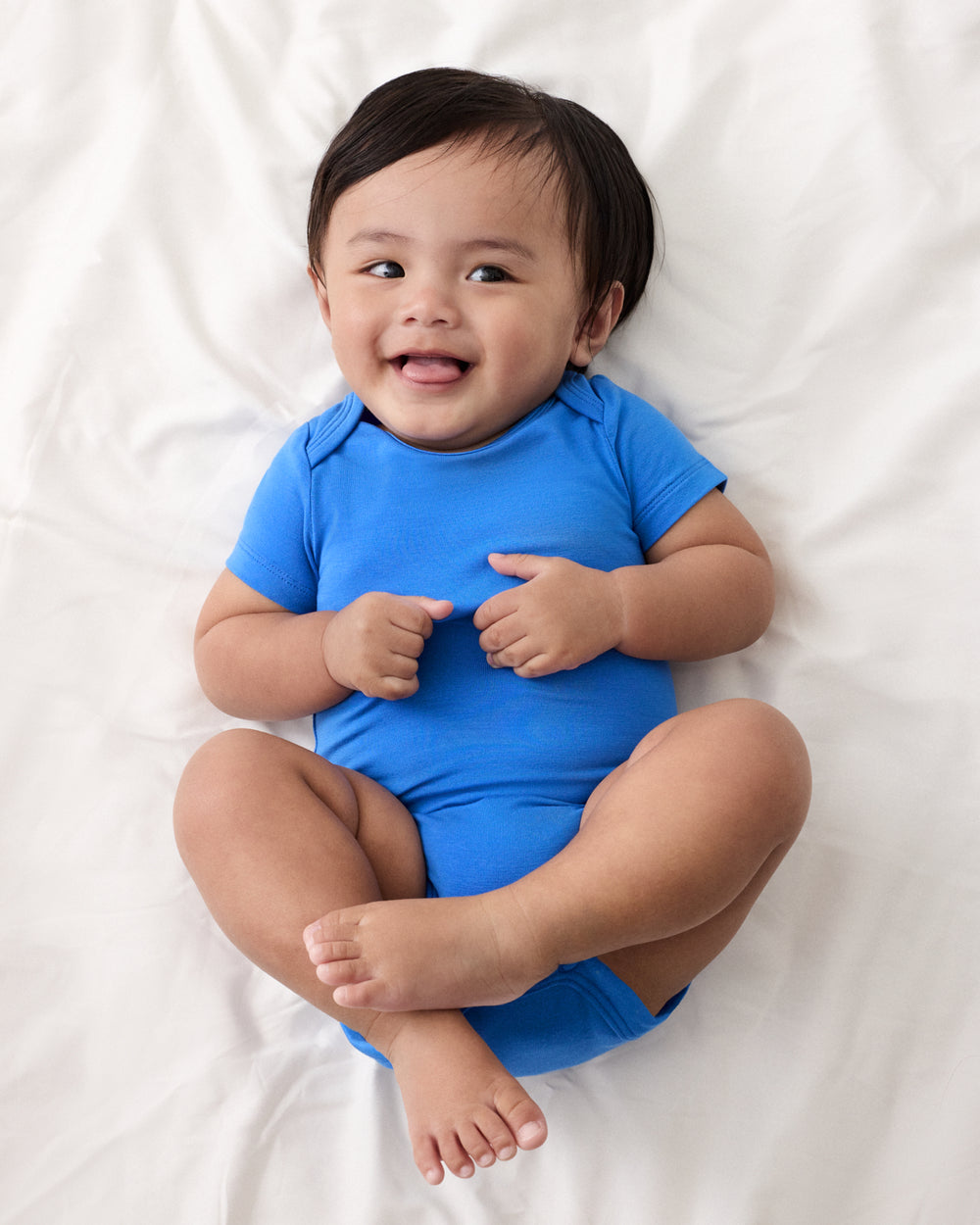 Baby wearing the Blue Bodysuit from the Rainbow Trucks Overall Set