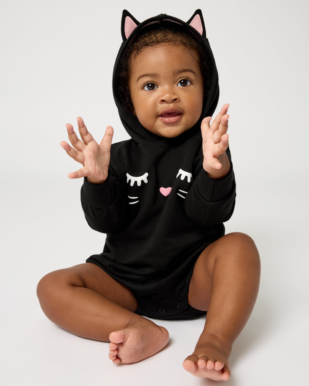 Sitting baby wearing the Black Cat Hoodie Romper