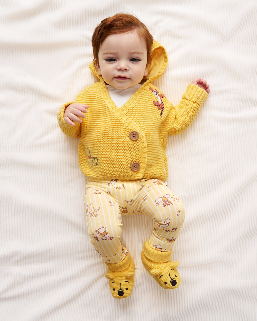 Aerial view of newborn wearing a Winnie The Pooh outfit
