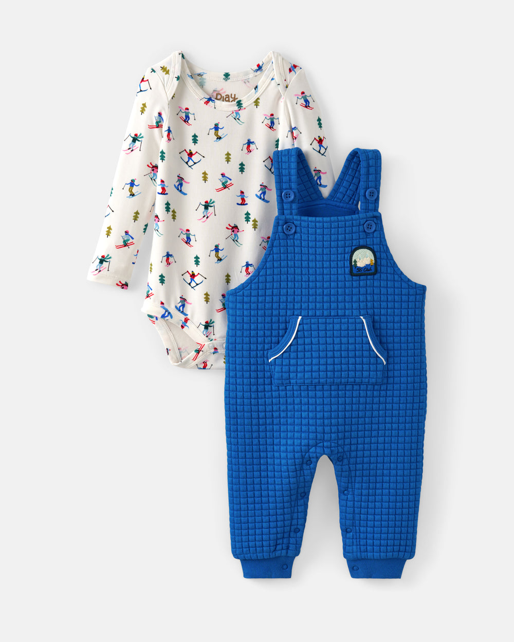 A two-piece baby clothing set featuring a long-sleeve bodysuit in off-white with a colorful ski pattern, and a pair of bright blue grid-patterned overall pants with a small patch on the chest, displayed on a light gray background.
