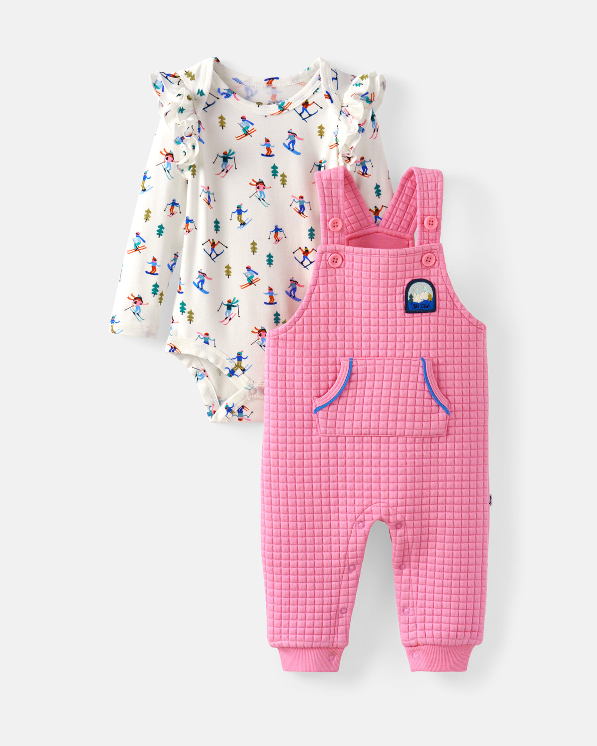 A baby clothing set featuring a pink textured overall romper and a white long-sleeve bodysuit with a colorful ski pattern, displayed against a light gray background.