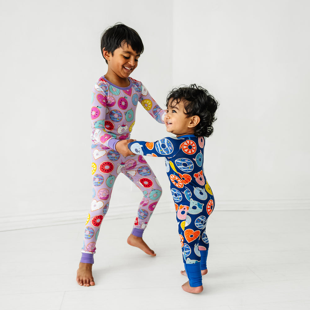 Click to see full screen - two children dancing wearing coordinating Blue and Lavender Donut Dream two piece and Zippy style pajamas