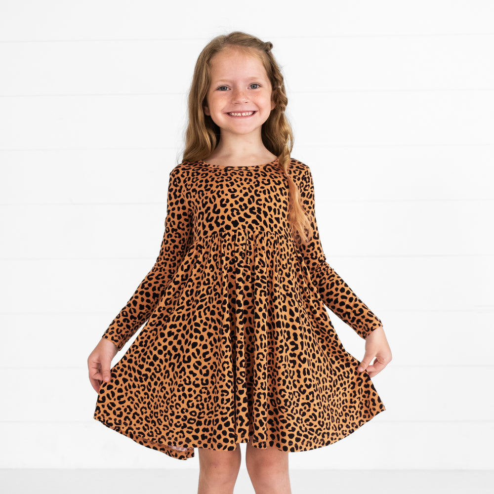 Image of a child holding out the sides of a Classic Leopard Twirl Dress