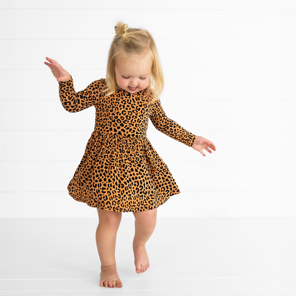 Image of a child spinning around in a Classic Leopard Twirl Dress with Bodysuit