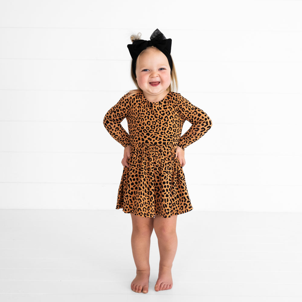 Alternate image of a child with her hands on her hips wearing a Classic Leopard Twirl Dress with Bodysuit and Cat Ears Luxe Bow Headband