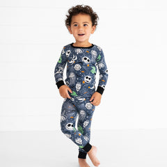 Child posing wearing a Jack and Crew printed two piece pj set