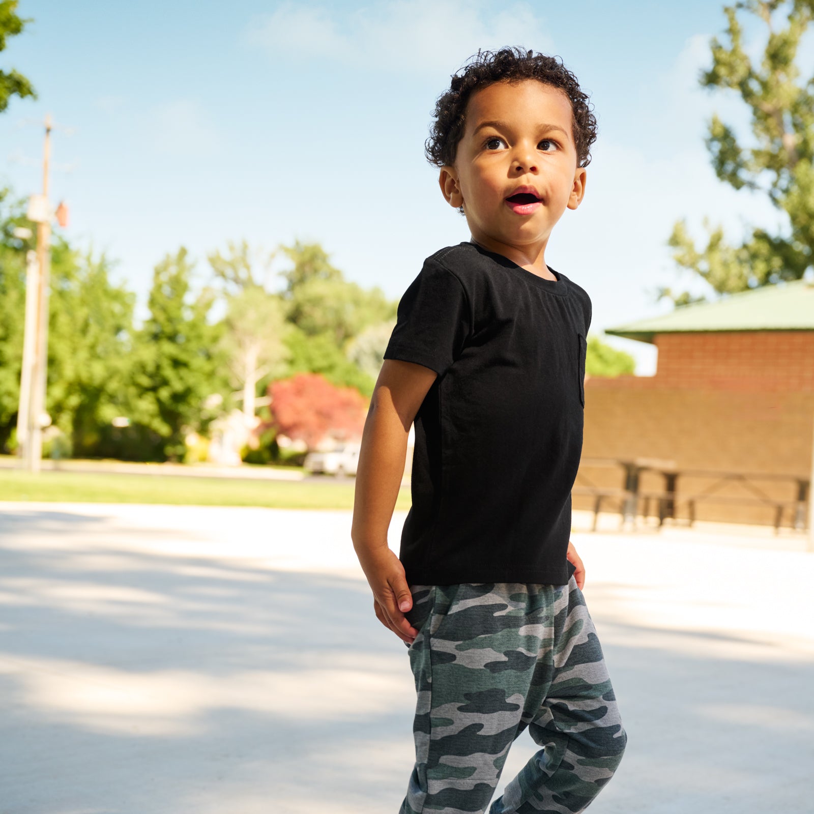 boy wearing Black Short Sleeve Relaxed Pocket Tee with camo joggers