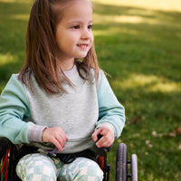 girl in wheelchair wearing aqua mist pocket crewneck