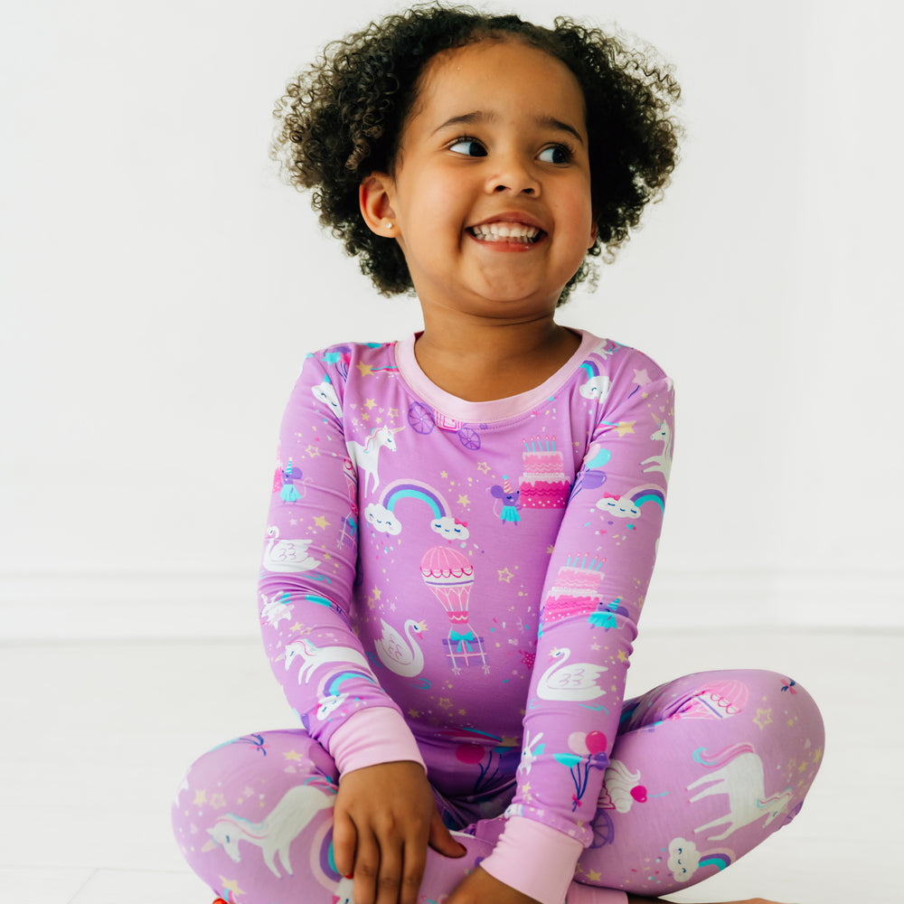 Child sitting wearing a Magical Birthday two piece pj set