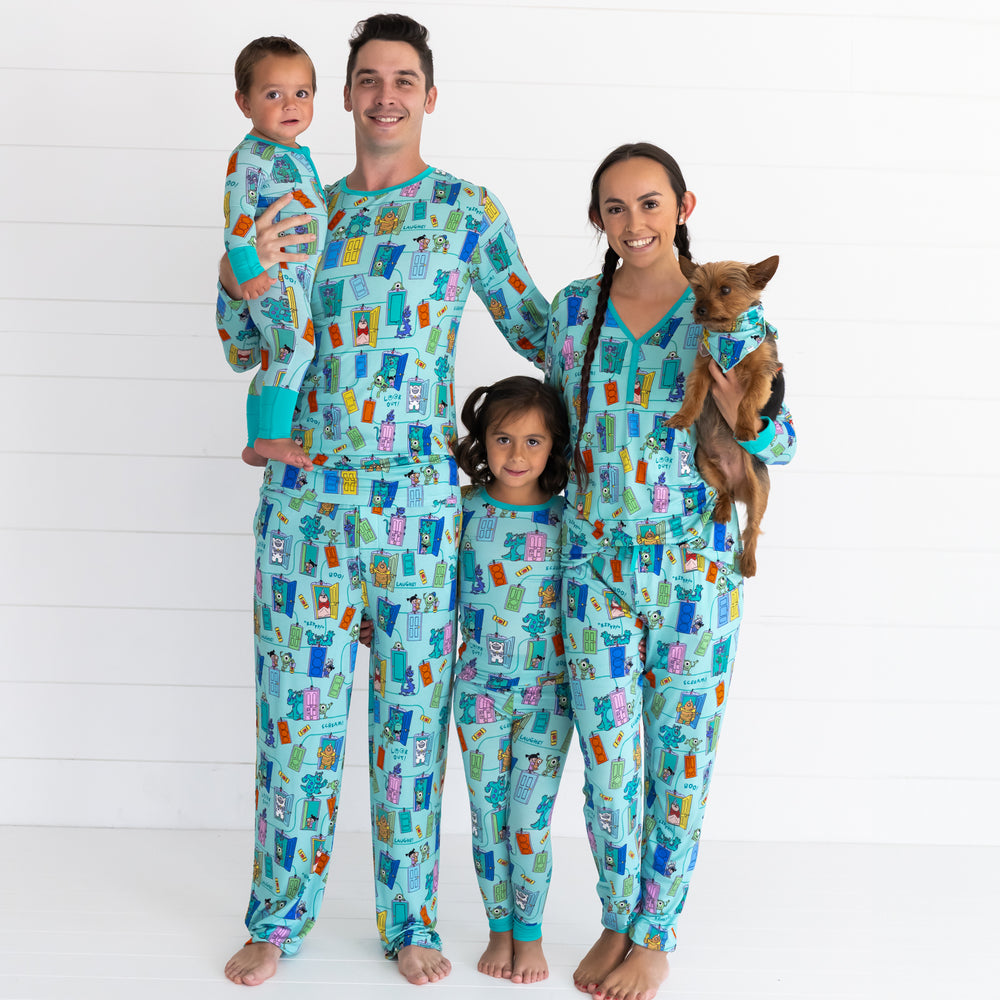 Family of four, inlcuding dog, all wearing the Disney Monsters, Inc. Scream Team print. Male model is wearing the Disney Monsters, Inc. Scream Team Men's Pajama Pants and Disney Monsters, Inc. Scream Team Men's Pajama Top