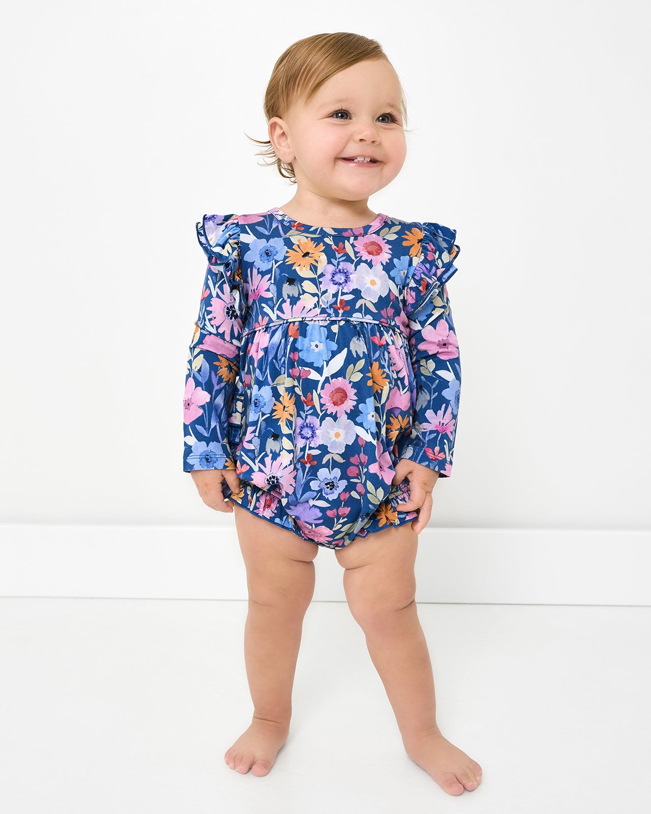 Standing toddler wearing the Dusk Blooms Bubble Romper