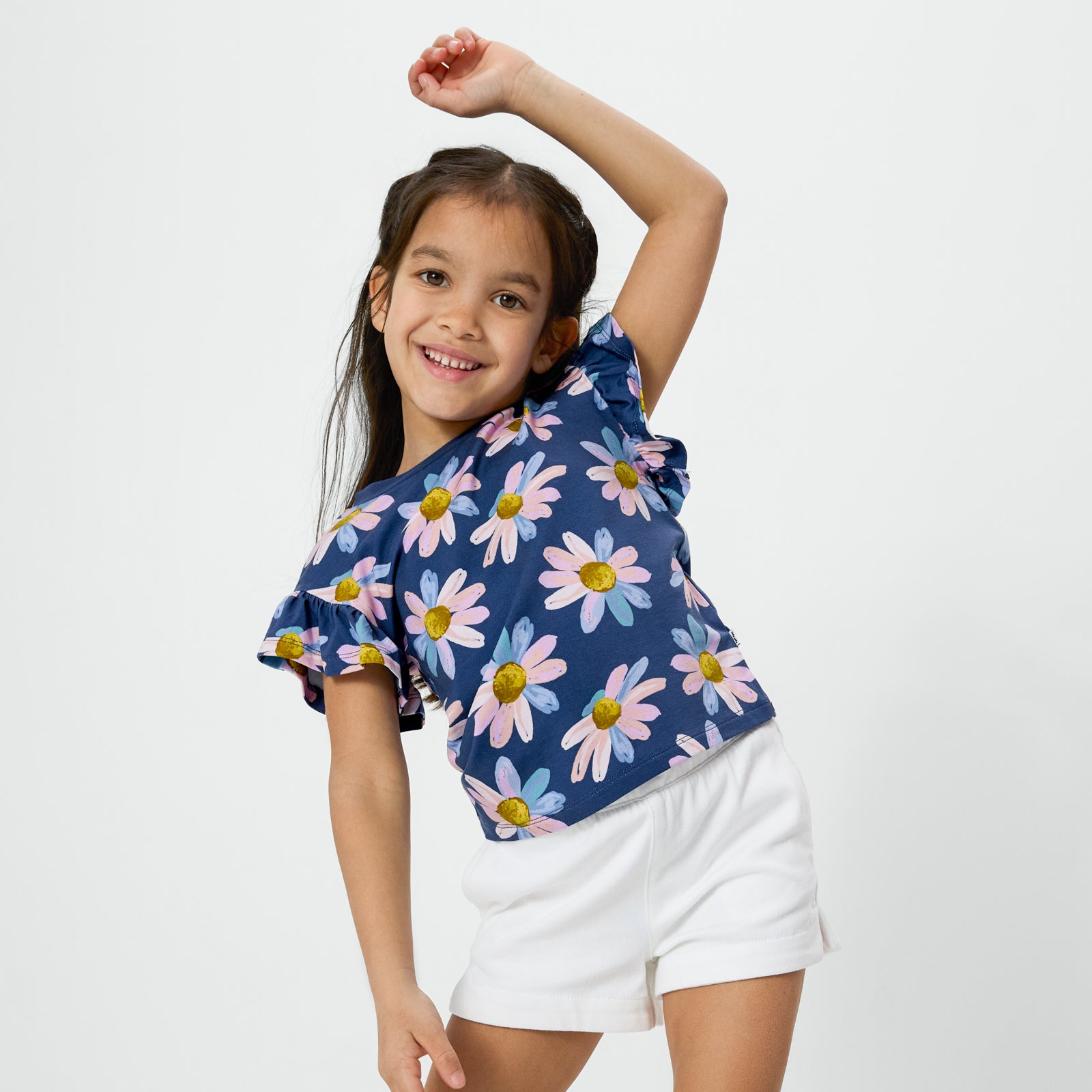 Posing child wearing the Daisy Blooms Flutter Tee