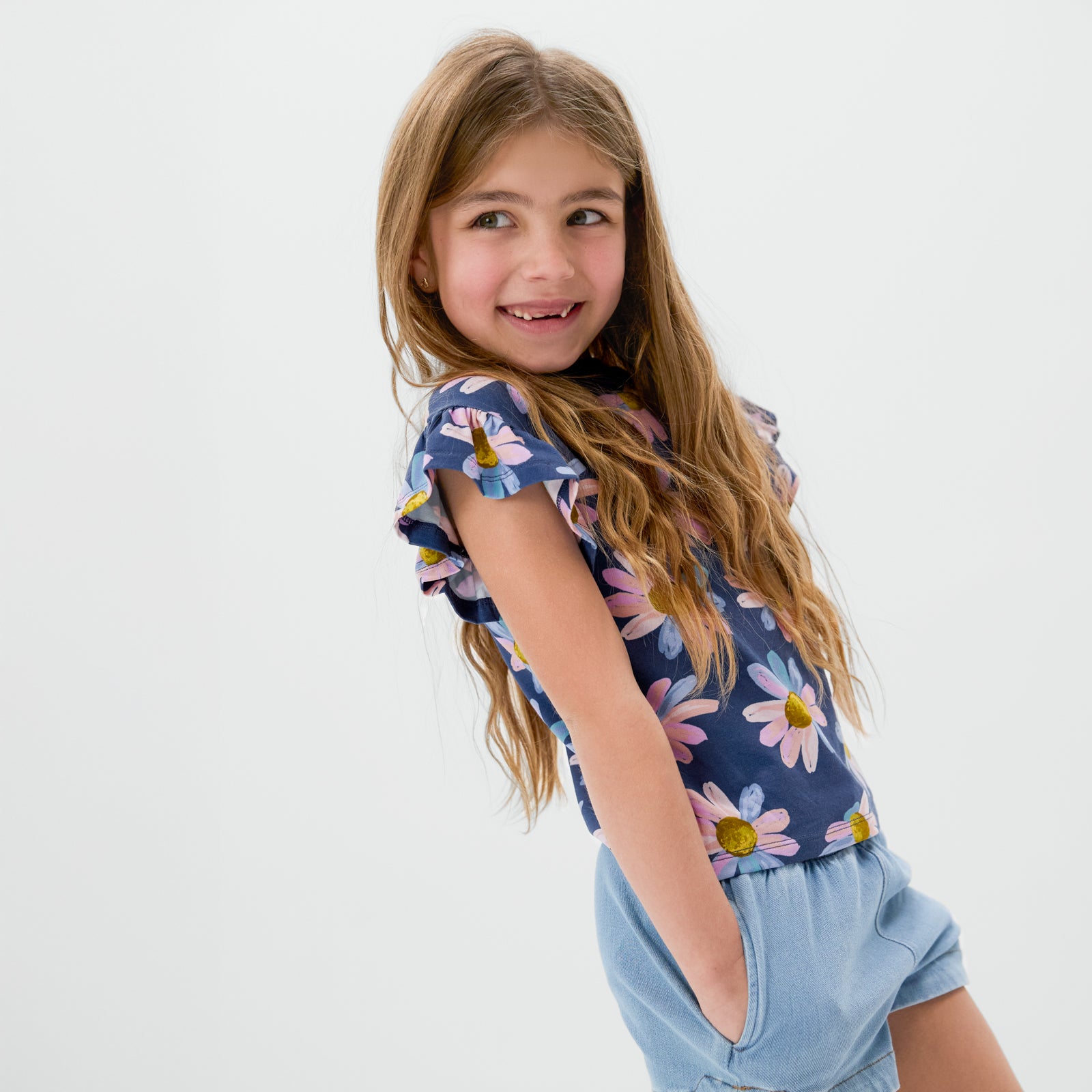 Child wearing the Daisy Blooms Flutter Tee with denim shorts