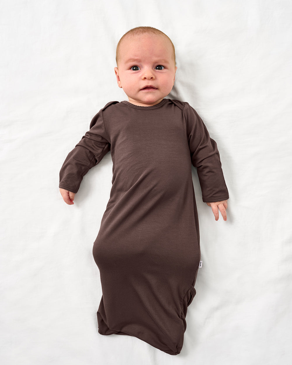 Aerial view of baby wearing the Dark Chocolate Infant Gown