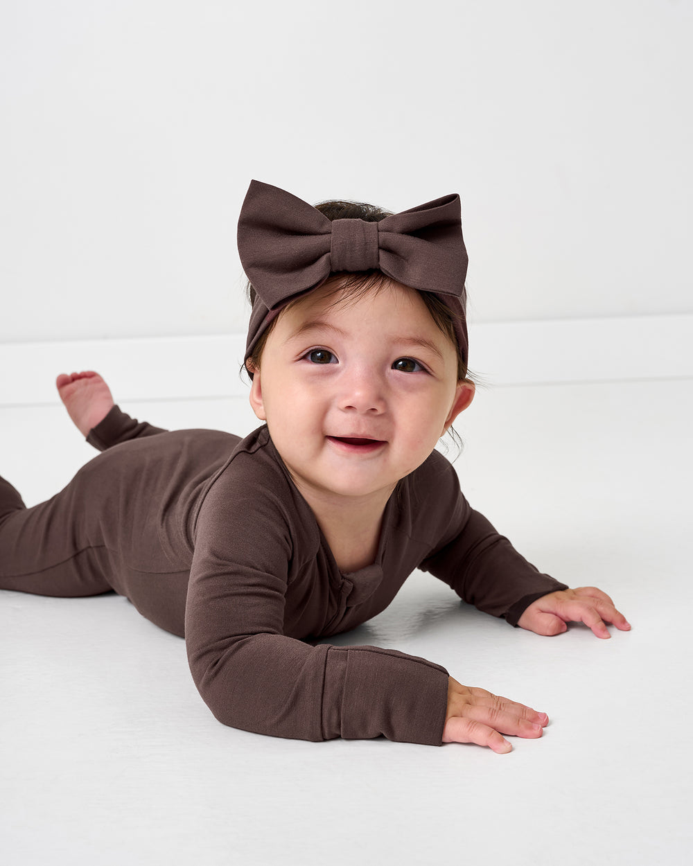 Baby on her tummy wearing the Dark Chocolate Luxe Bow Headband