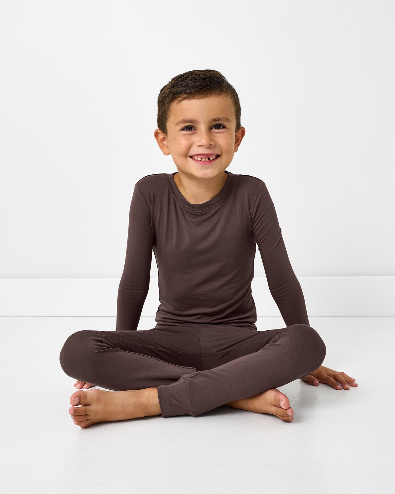Sitting boy wearing the Dark Chocolate Two-Piece Pajama Set