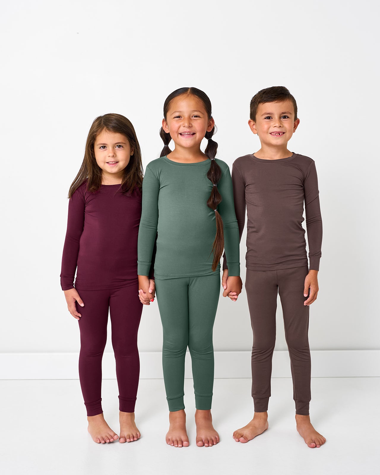 Three kids wearing pajama sets from our Fall Solids color way