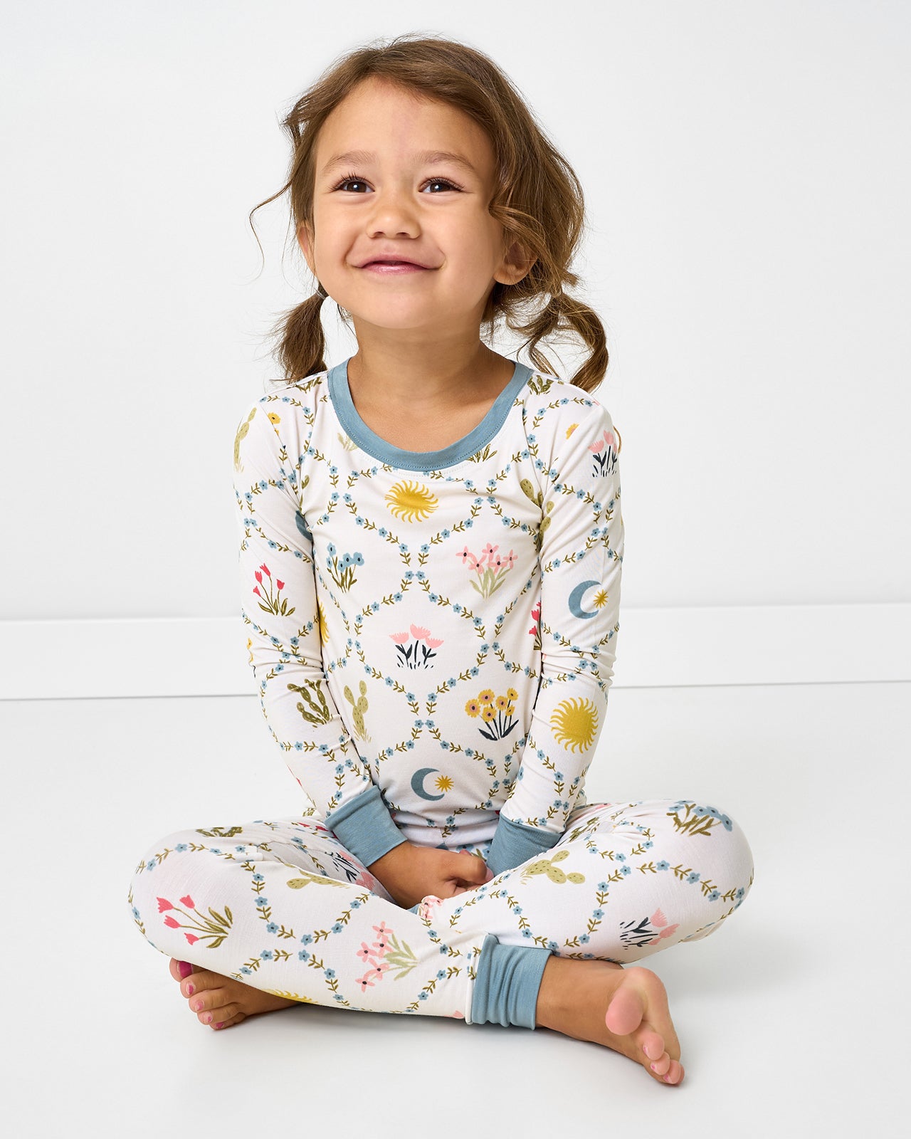 Sitting girl wearing the Desert Meadow Two-Piece Pajama Set