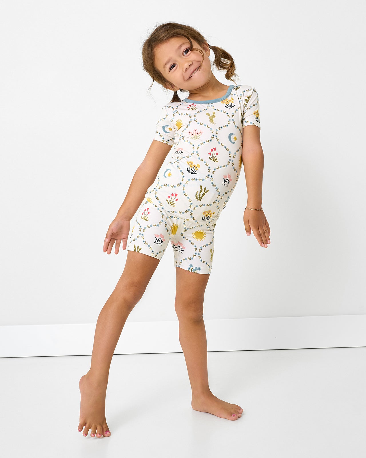 Standing girl wearing the Desert Meadow Two-Piece Short Sleeve & Shorts Pajama Set