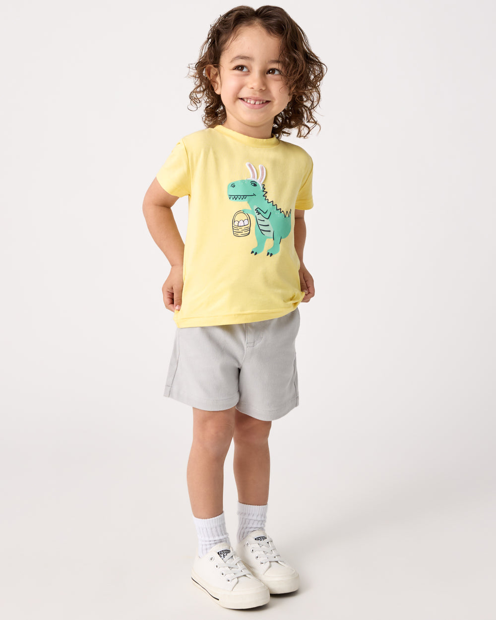Child wearing the Dino Egg Hunter Relaxed Tee with gray chino shorts