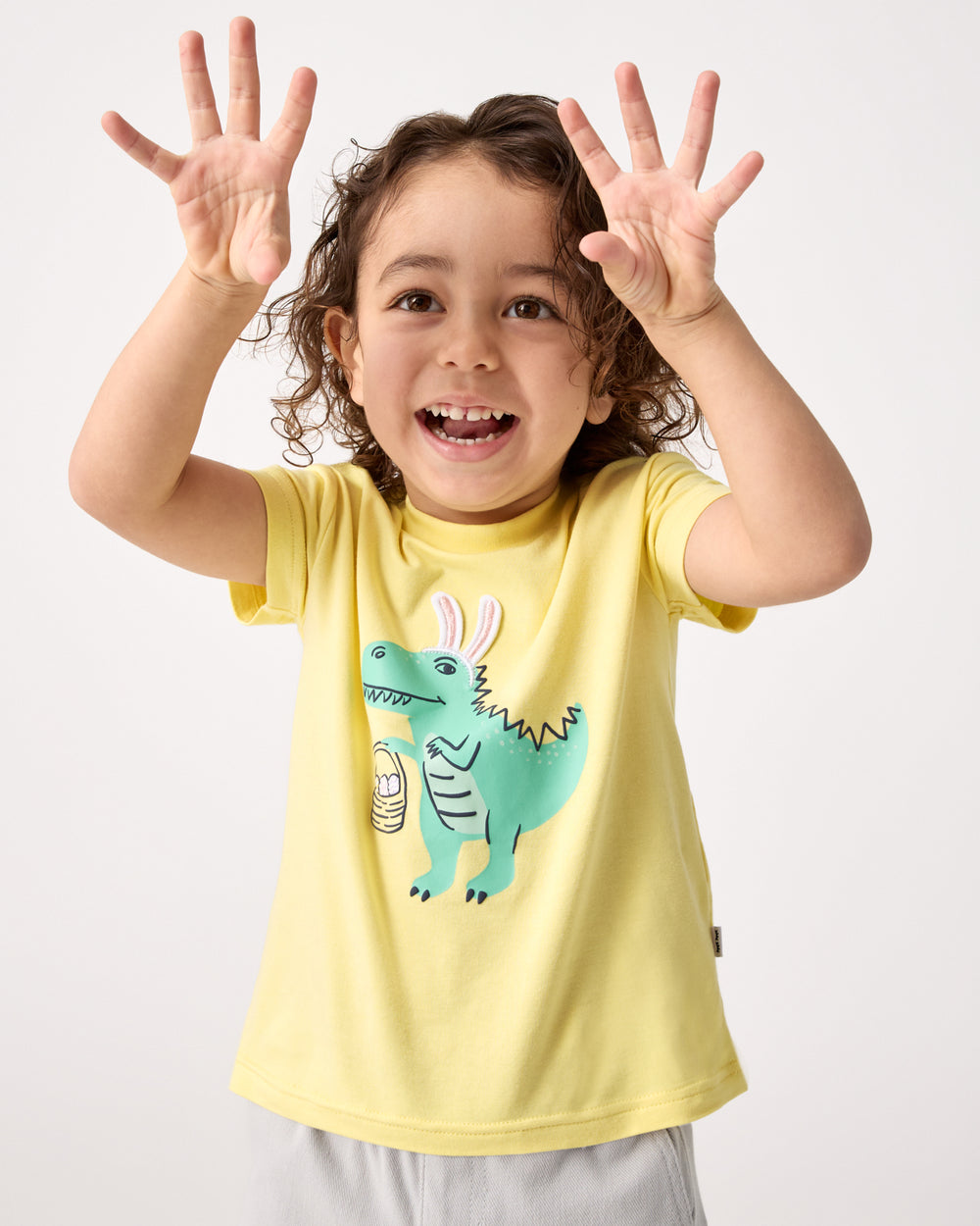 Posing child wearing the Dino Egg Hunter Relaxed Tee